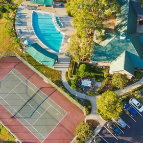 an aerial view of tennis court and pool